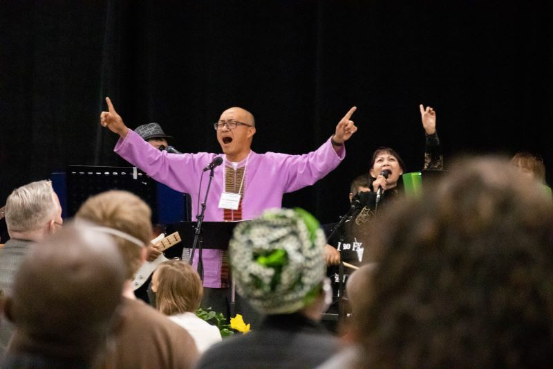 Man in purple raising hands in worship