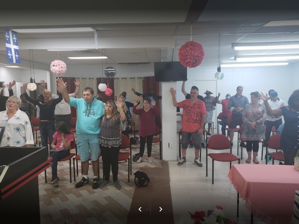 people raising hands in worship in room