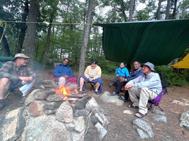 Group of men sitting at a bonfire